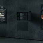 Dark wall with a framed poster of 'The Godfather' and built-in rack of Hegel C5 Series amplifiers.
