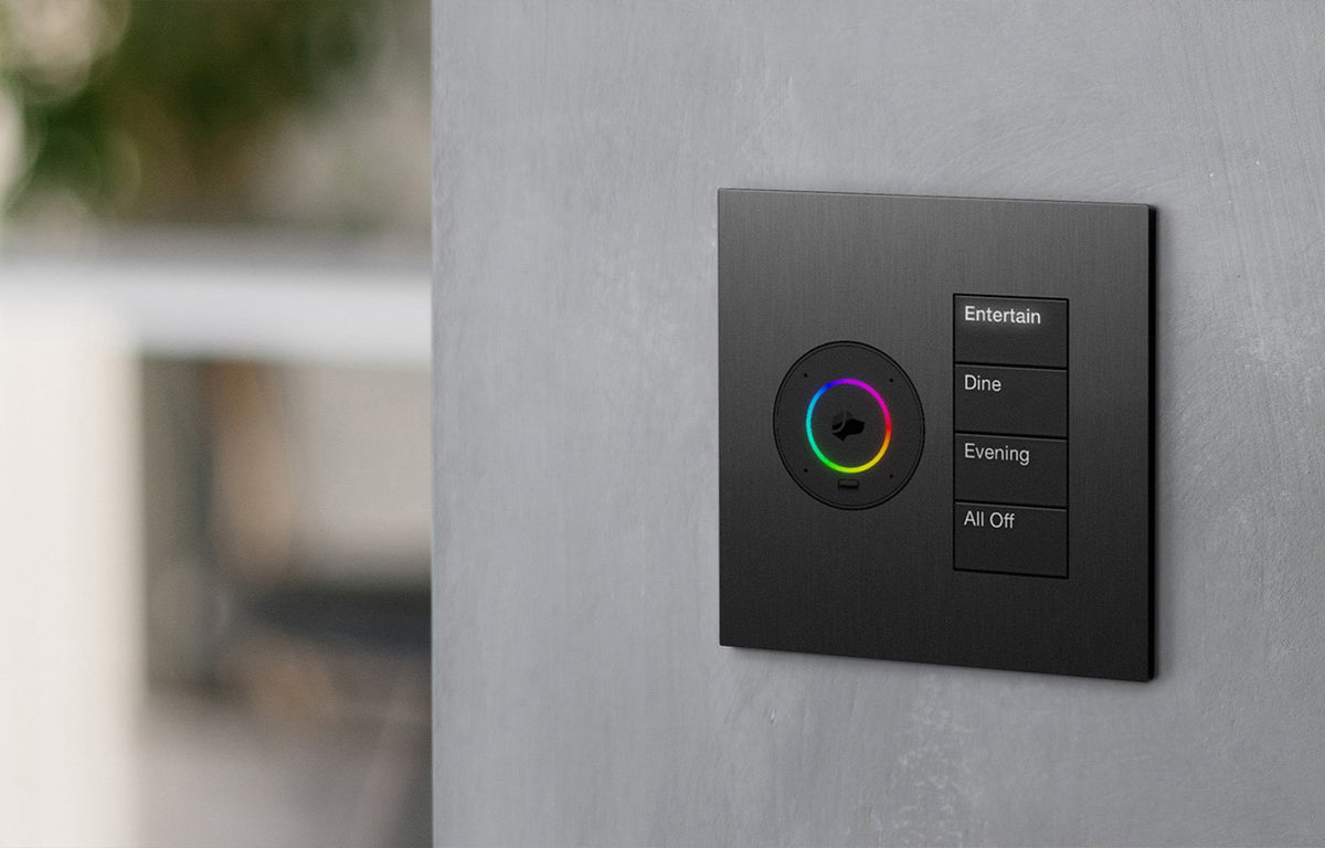 Lutron and Josh.ai Palladiom matte black brushed metal wall plate on grey textured wall.