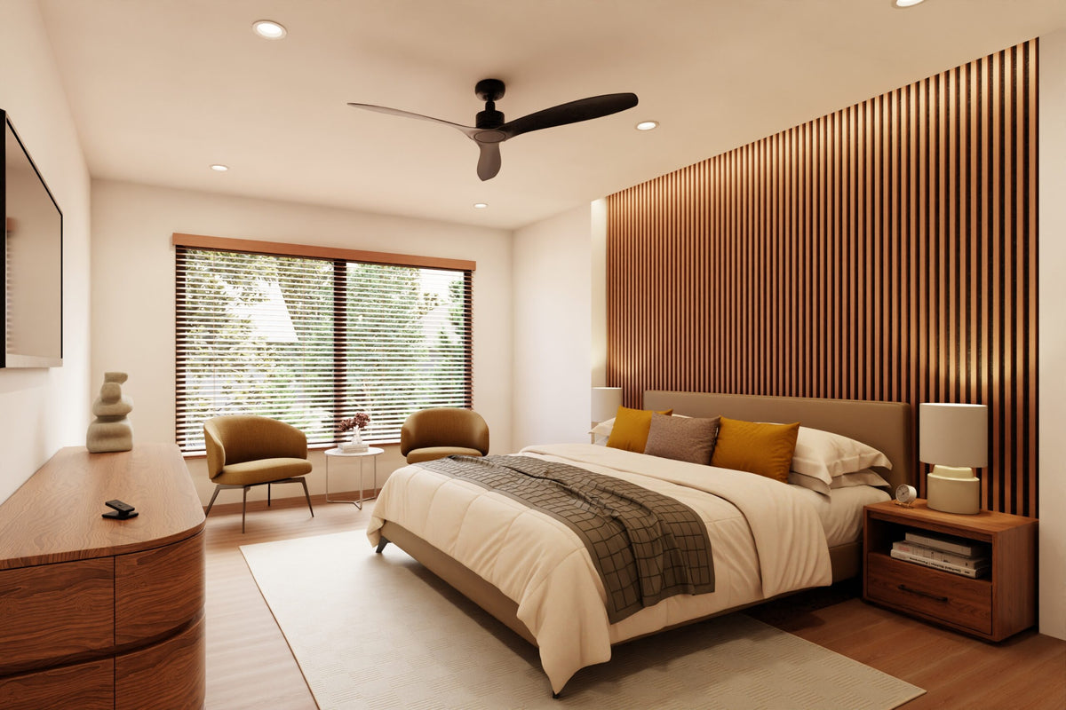 A modern bedroom interior featuring a bed with white bedding and mustard yellow pillows, set against a slatted wood accent wall. The room includes a wooden dresser, two upholstered armchairs by a window with motorized Lutron Sivoia blinds, a ceiling fan, and a light rug.