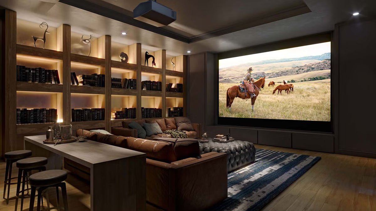 Modern Sony projection home theater with bookshelves, sofa, and movie screen displaying a horse scene.